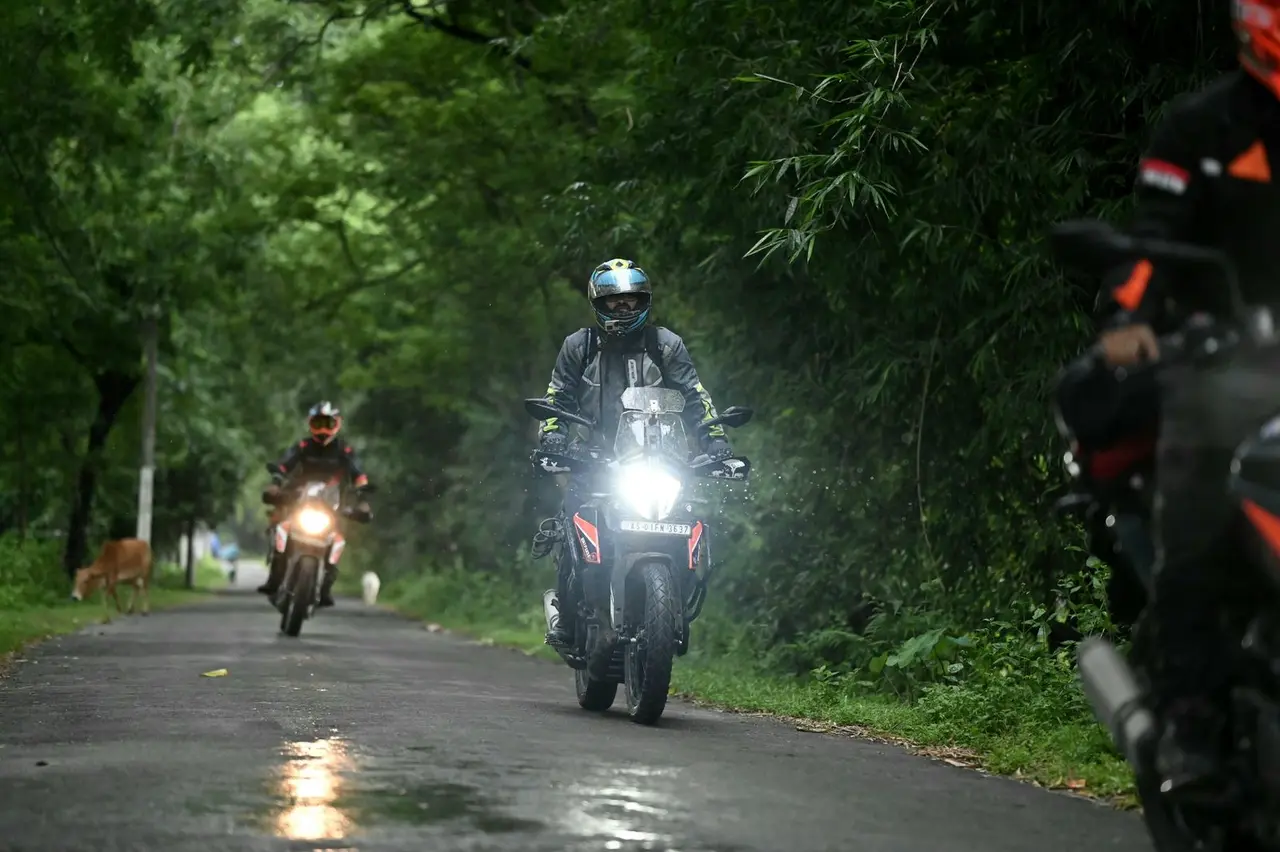 Motorcyclists on a scenic forest road adventure, showcasing motorbike travel and exploration.