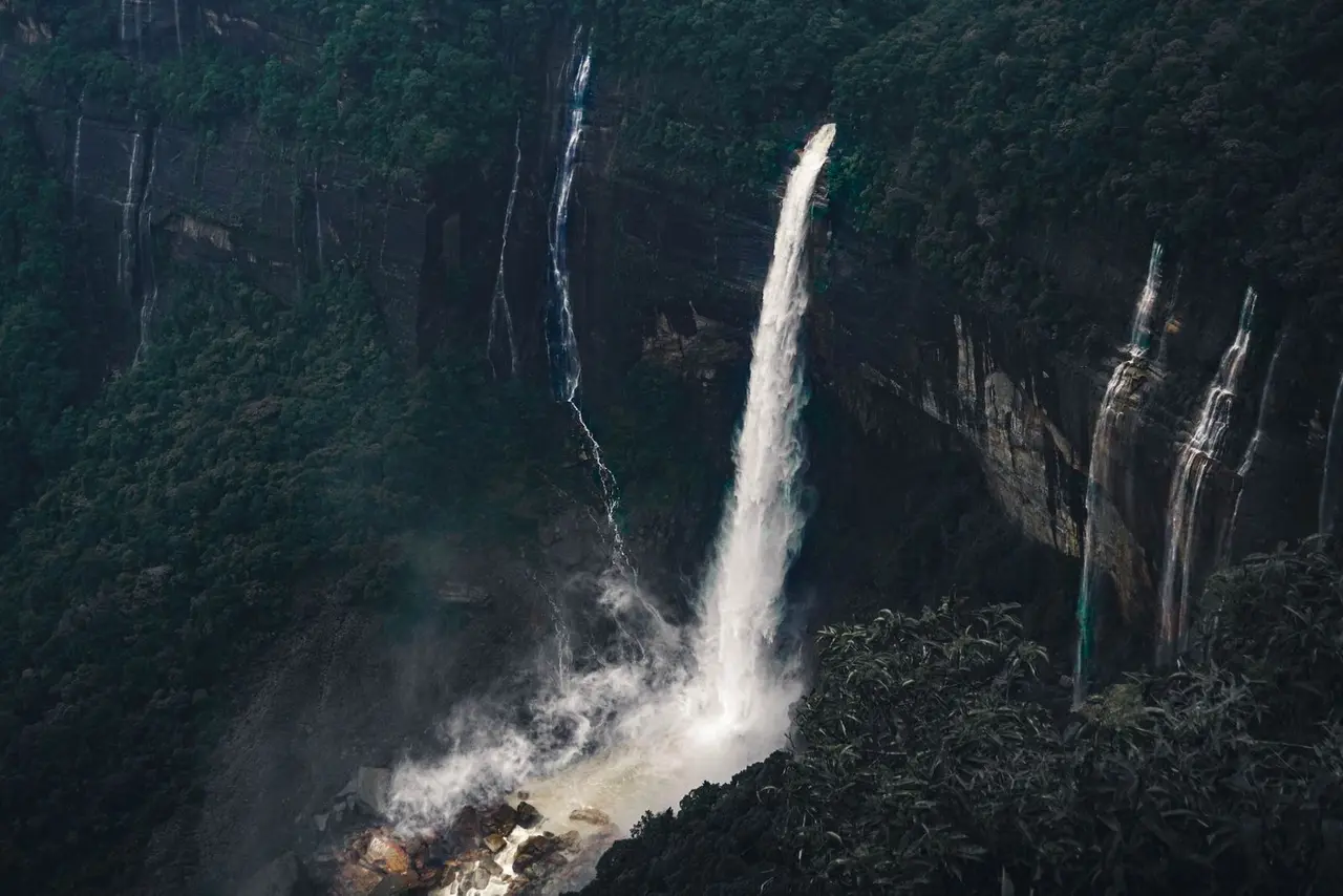 A breathtaking view of waterfalls cascading in the lush forests of Shillong, India.